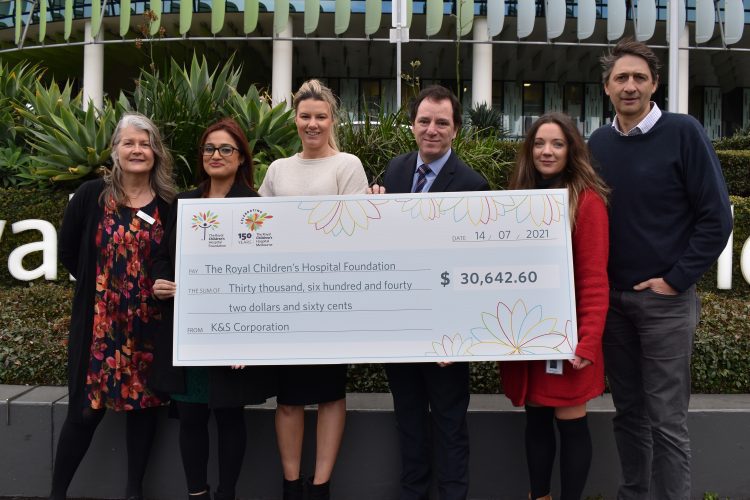 Six people hold a large cheque outside the RCH
